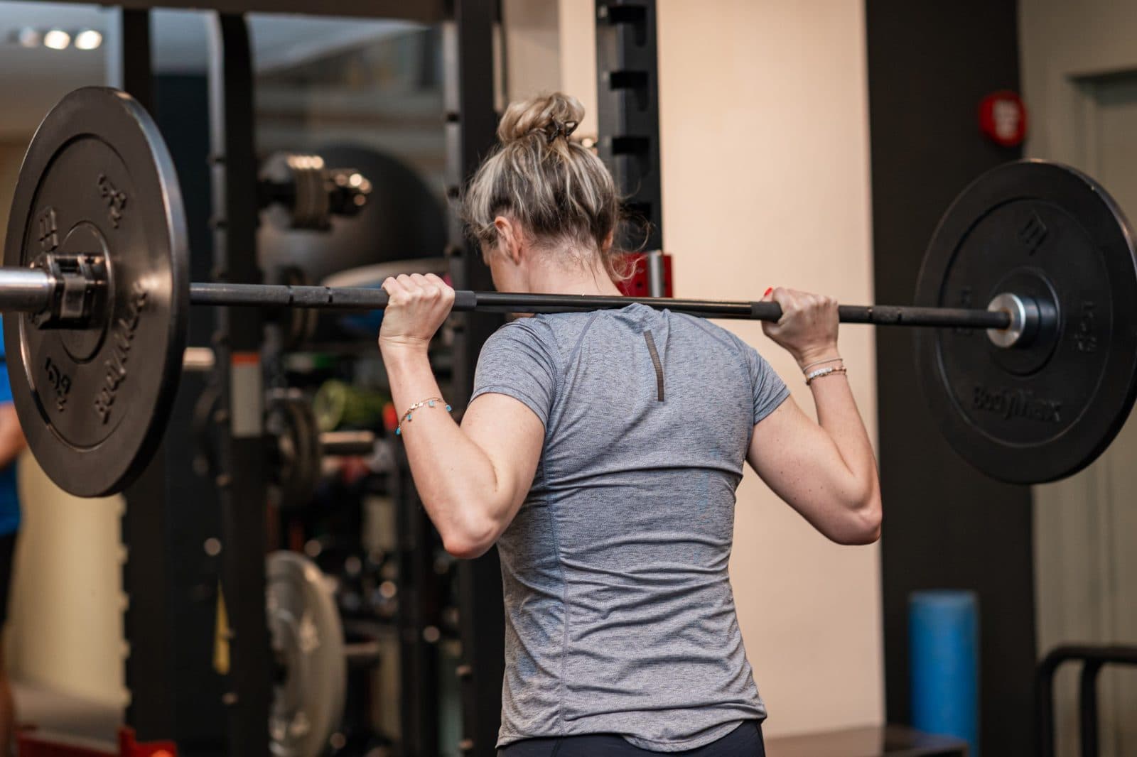 Client performing a back squat during a personal training session near Battersea