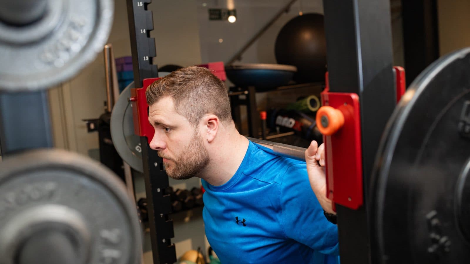 Client performing a back squat during a personal training session in Clapham